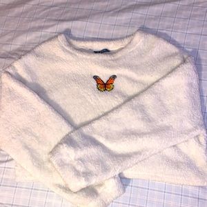 cropped fussy sweater with butterfly stitched to the front.